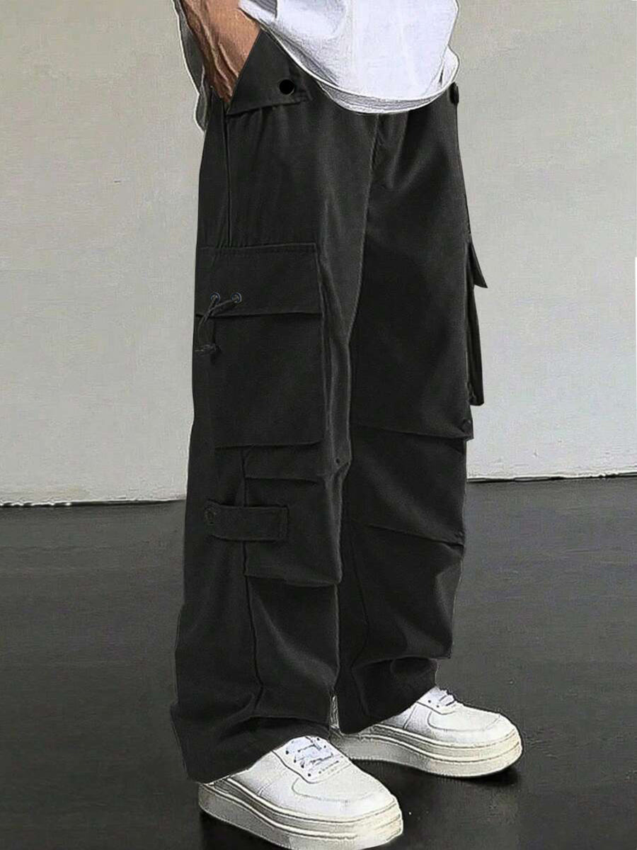Black cargo pants with multiple pockets and drawstring details, styled with white sneakers.