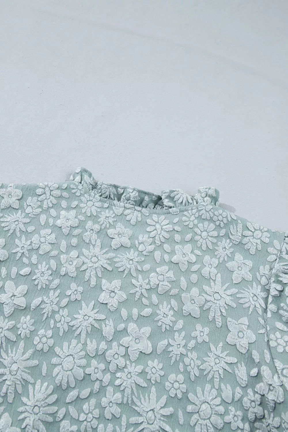 Embroidered floral puff sleeve shirt with ruffled neckline in light blue polyester.