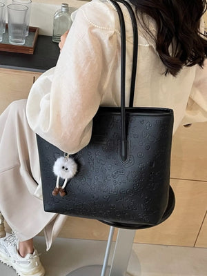 Black embossed PU leather tote bag with cartoon pattern and fluffy keychain.