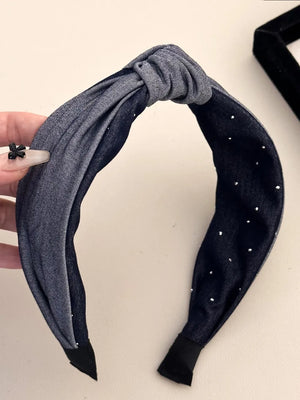 Denim knot headband with crystal detail in dark gray, featuring a knotted front and scattered rhinestones.