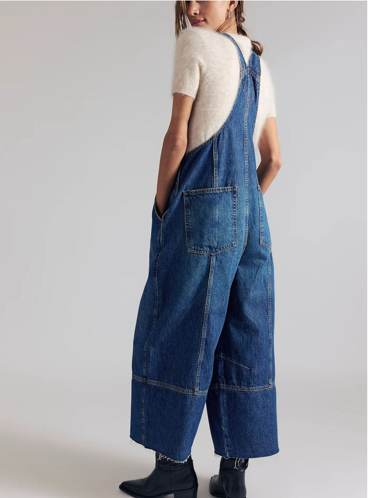 Light blue denim overalls with wide legs and raw hem, featuring adjustable straps and button-down sides.