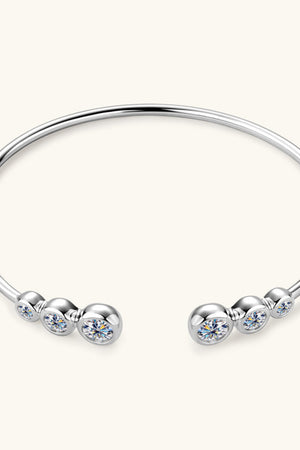 Silver open-ended cuff bracelet with bezel-set moissanite stones and polished spheres.