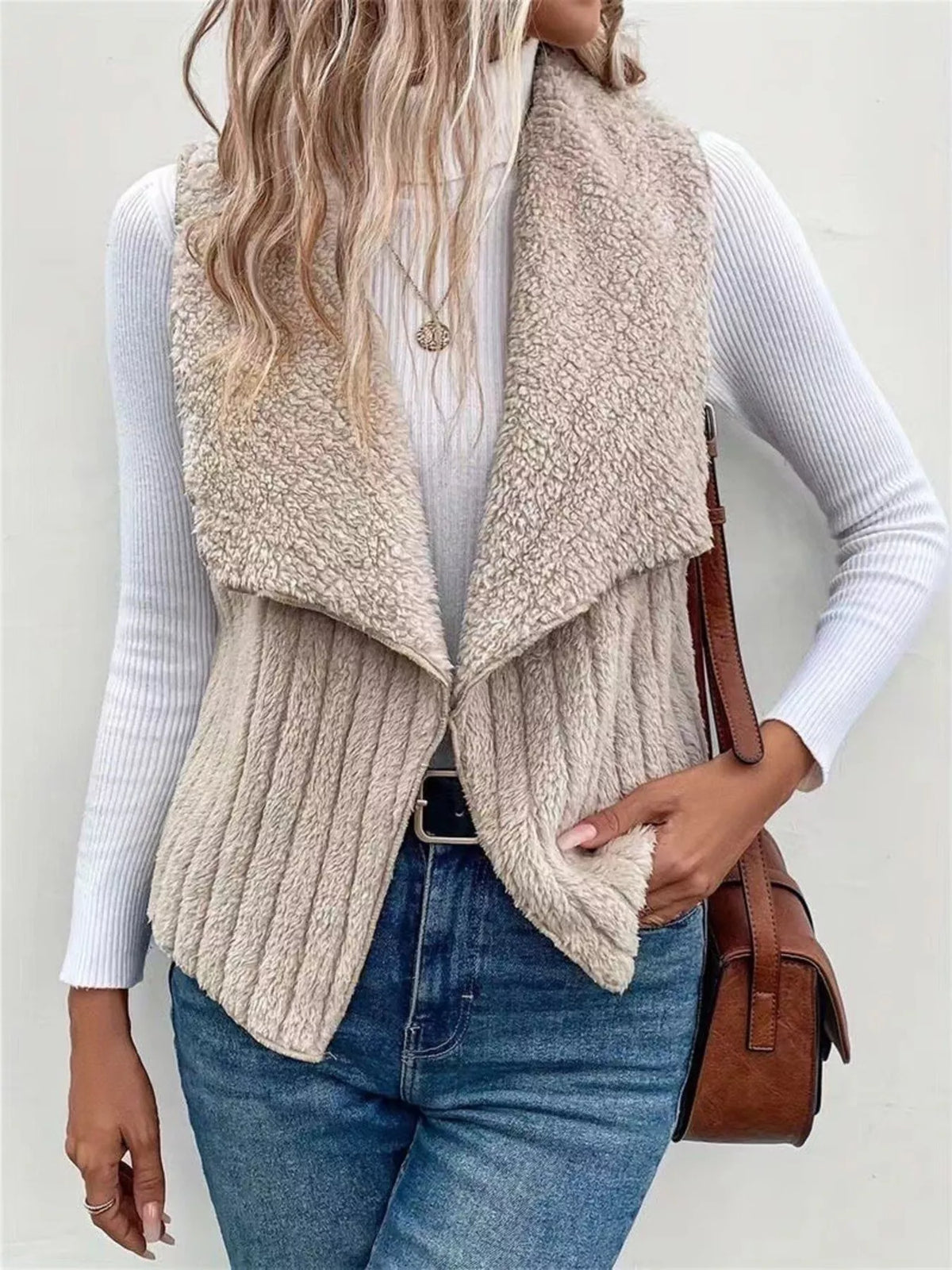 Cozy open front fleece vest in beige with a shawl collar, ribbed texture, and open sides.