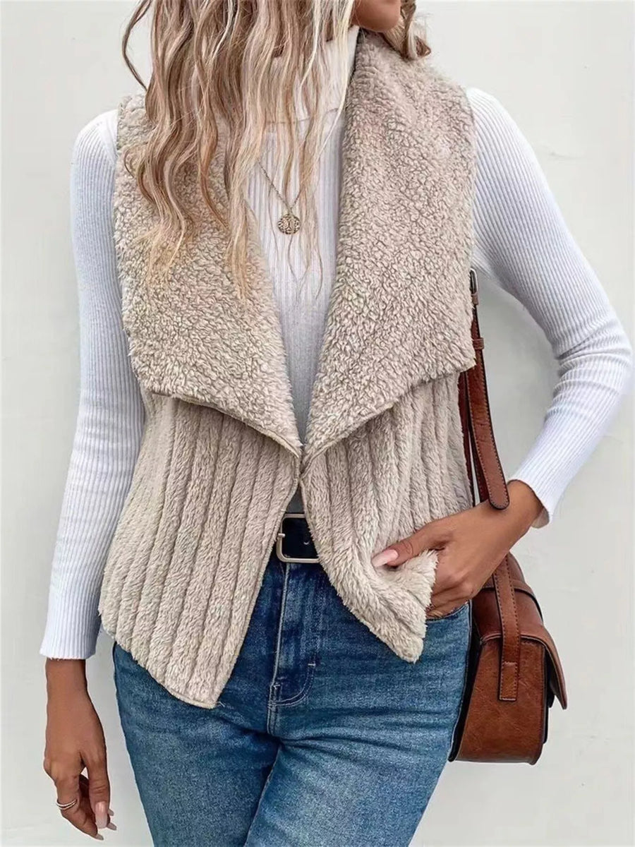 Cozy open front fleece vest in beige with a shawl collar, ribbed texture, and open sides.