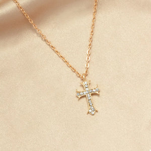 Gold rhinestone cross pendant necklace with delicate chain.