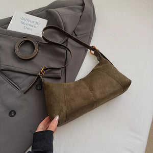 Chic suede crescent shoulder bag in coffee brown with adjustable strap.