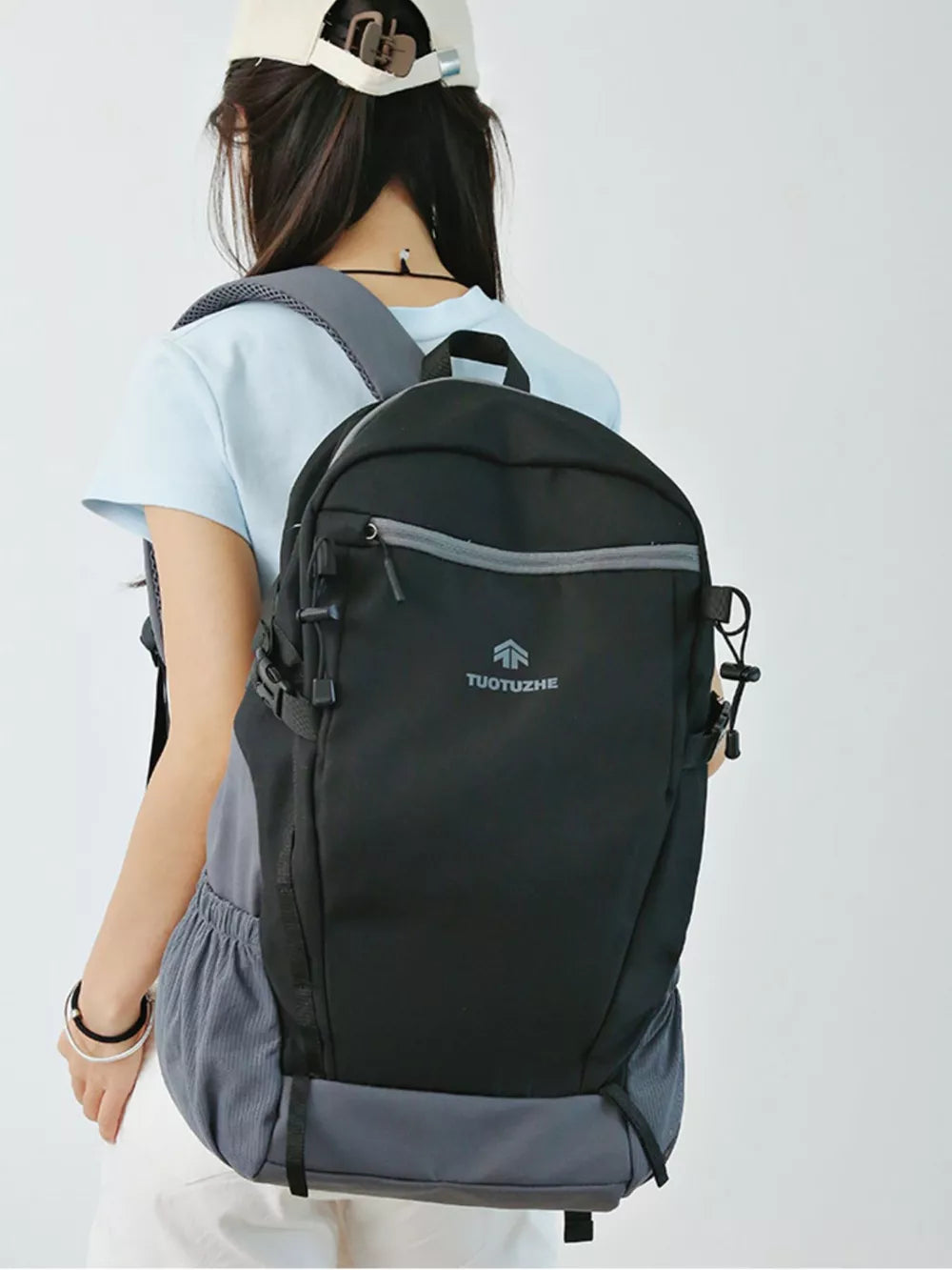 Black nylon backpack with gray accents and logo detail, worn by a woman.
