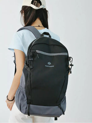 Black nylon backpack with gray accents and logo detail, worn by a woman.