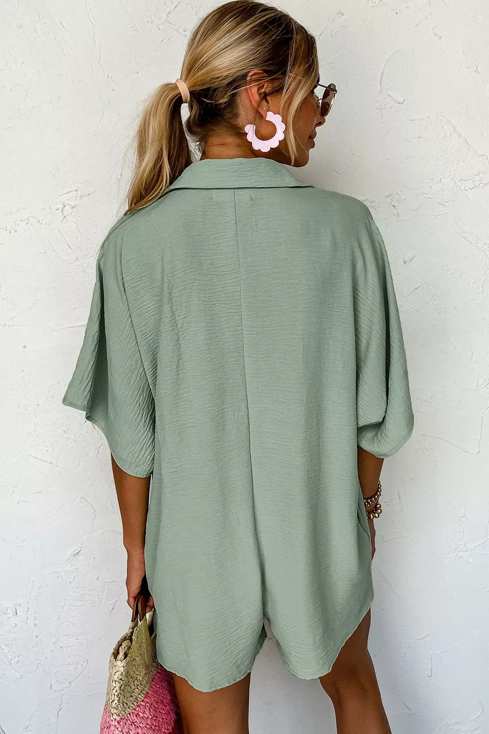Sage green collared button-down romper with half sleeves and textured fabric.