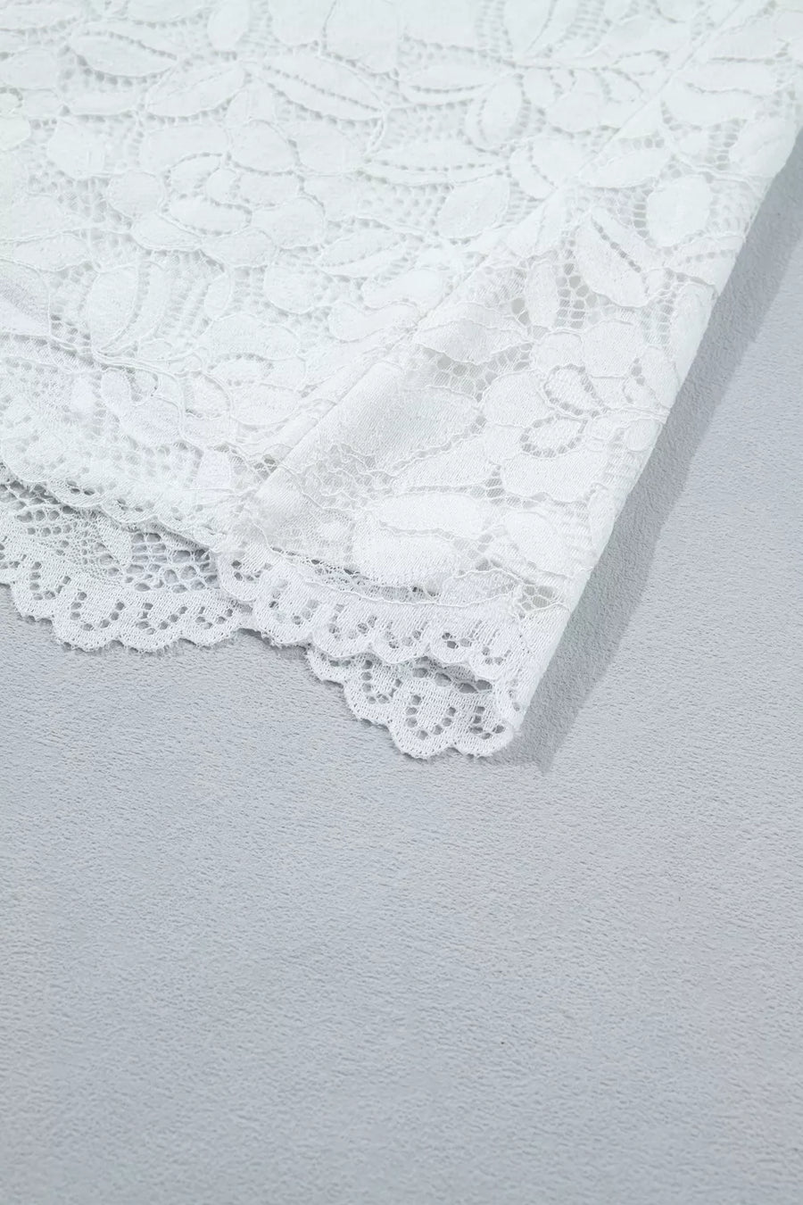 White lace blouse with ruffled hem detail