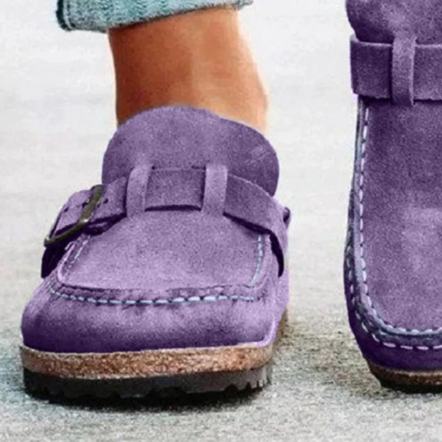 Purple suede buckle mule loafers with contrast stitching and cork sole.