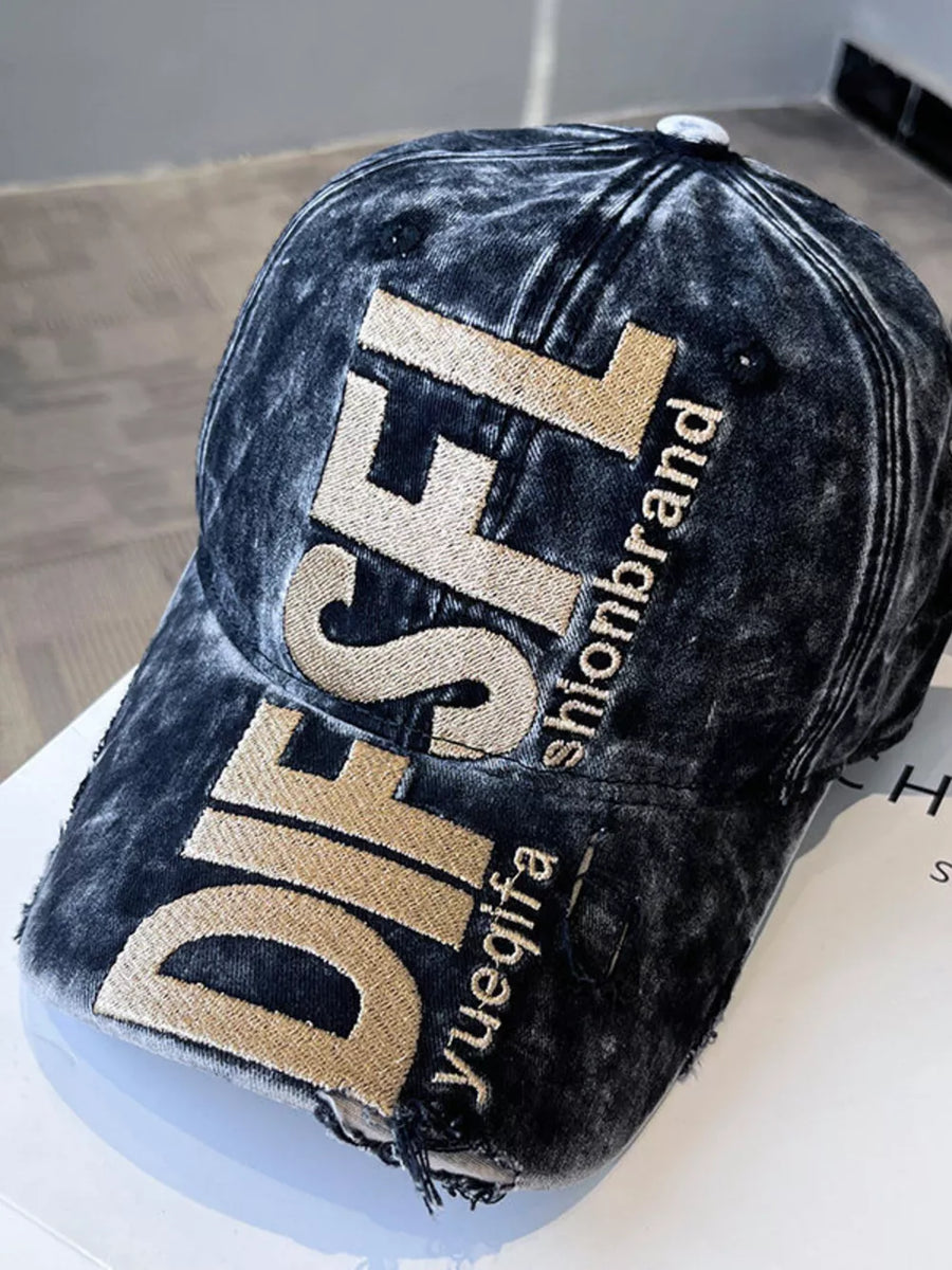 Distressed black baseball cap with gold embroidered text and frayed details.