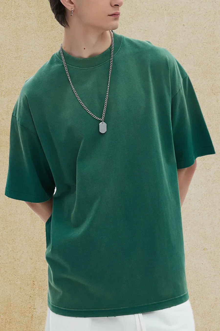 Oversized washed cotton crewneck tee in dark green with a silver chain necklace.