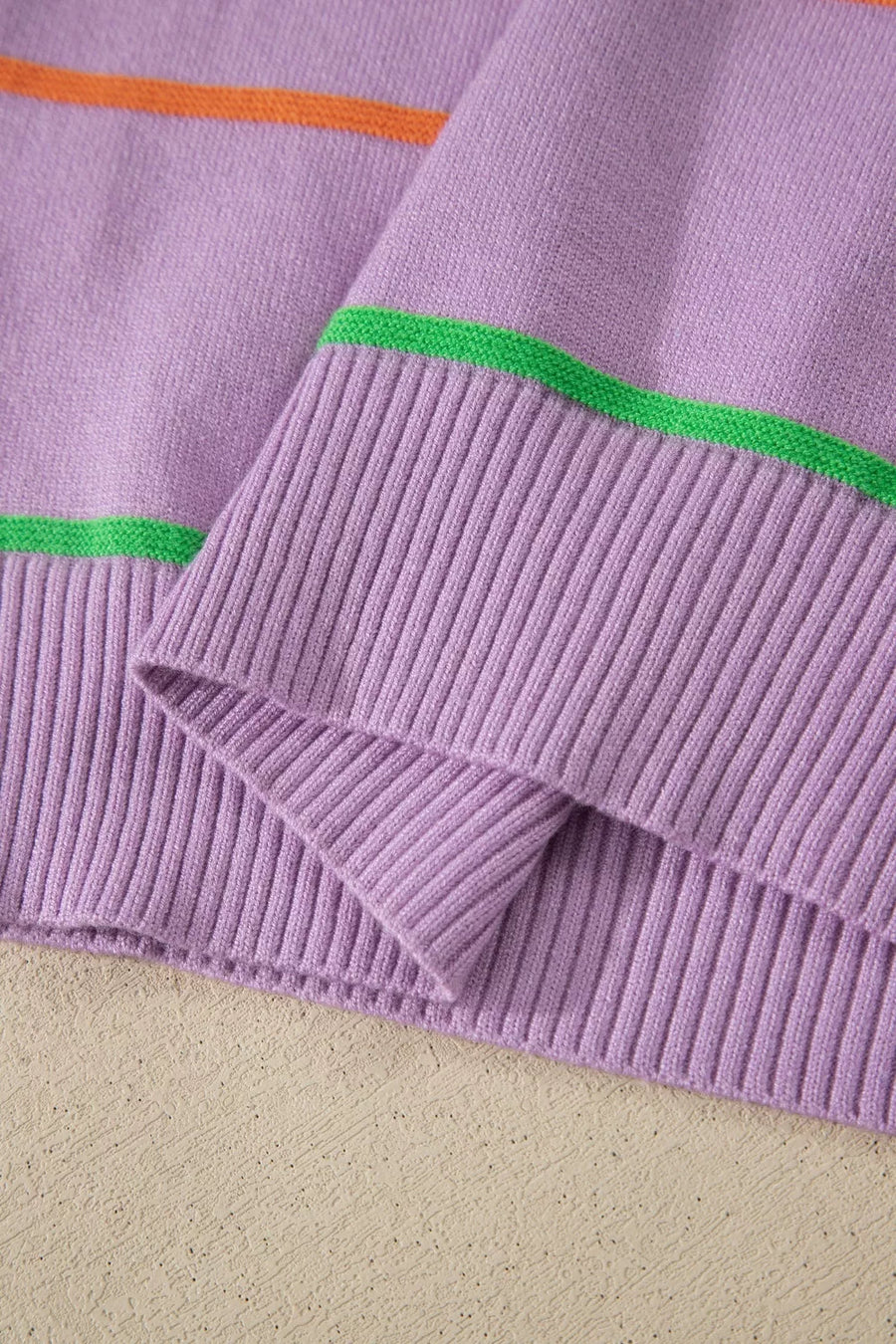 Lavender knit sweater vest with orange and green stripes and ribbed trim.