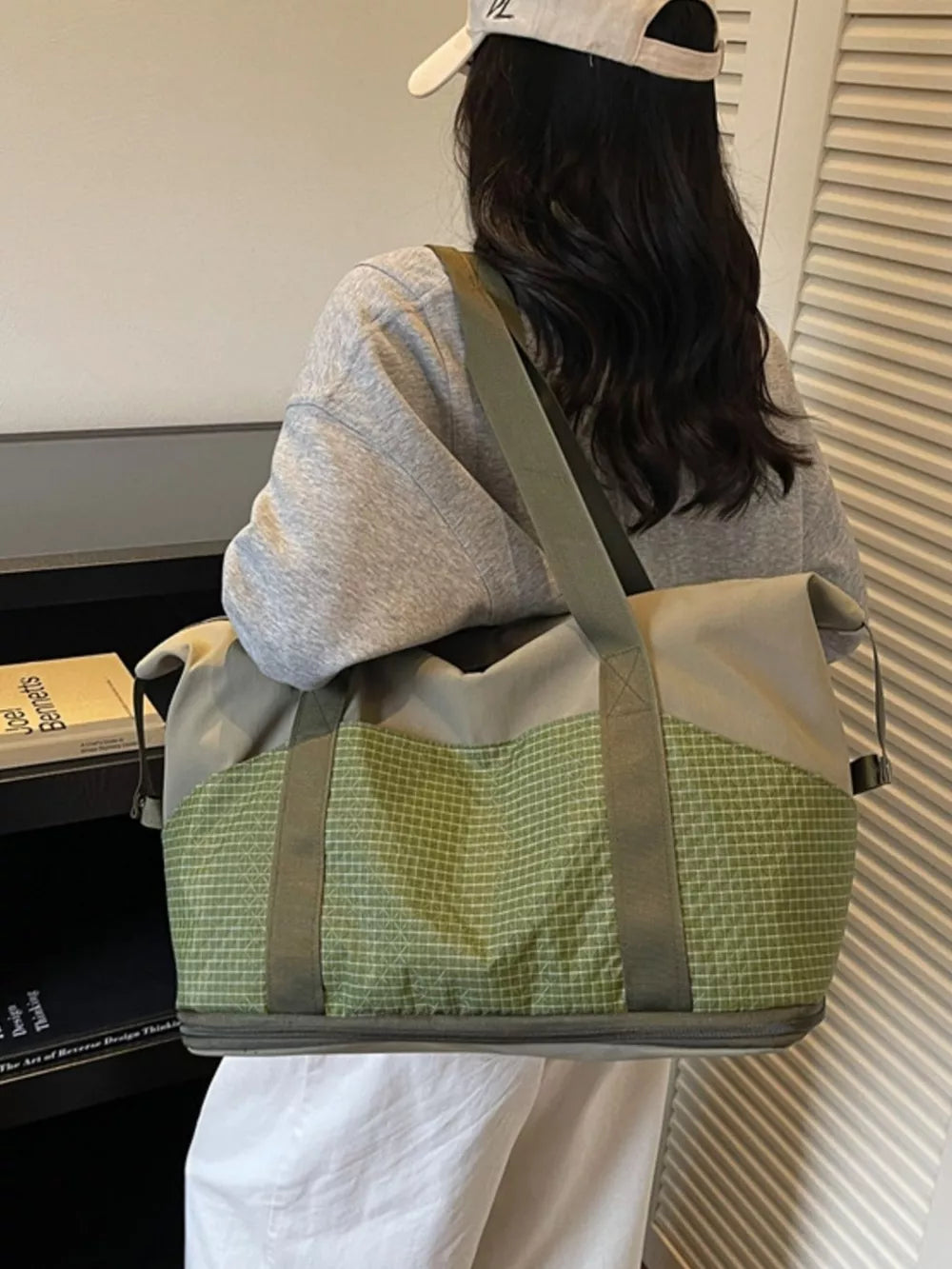 Spacious nylon travel duffel bag in army green with grid pattern detail.