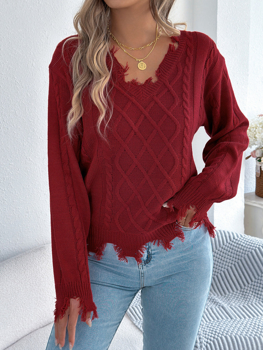 bright orange v-neck sweater featuring distressed and cable knit