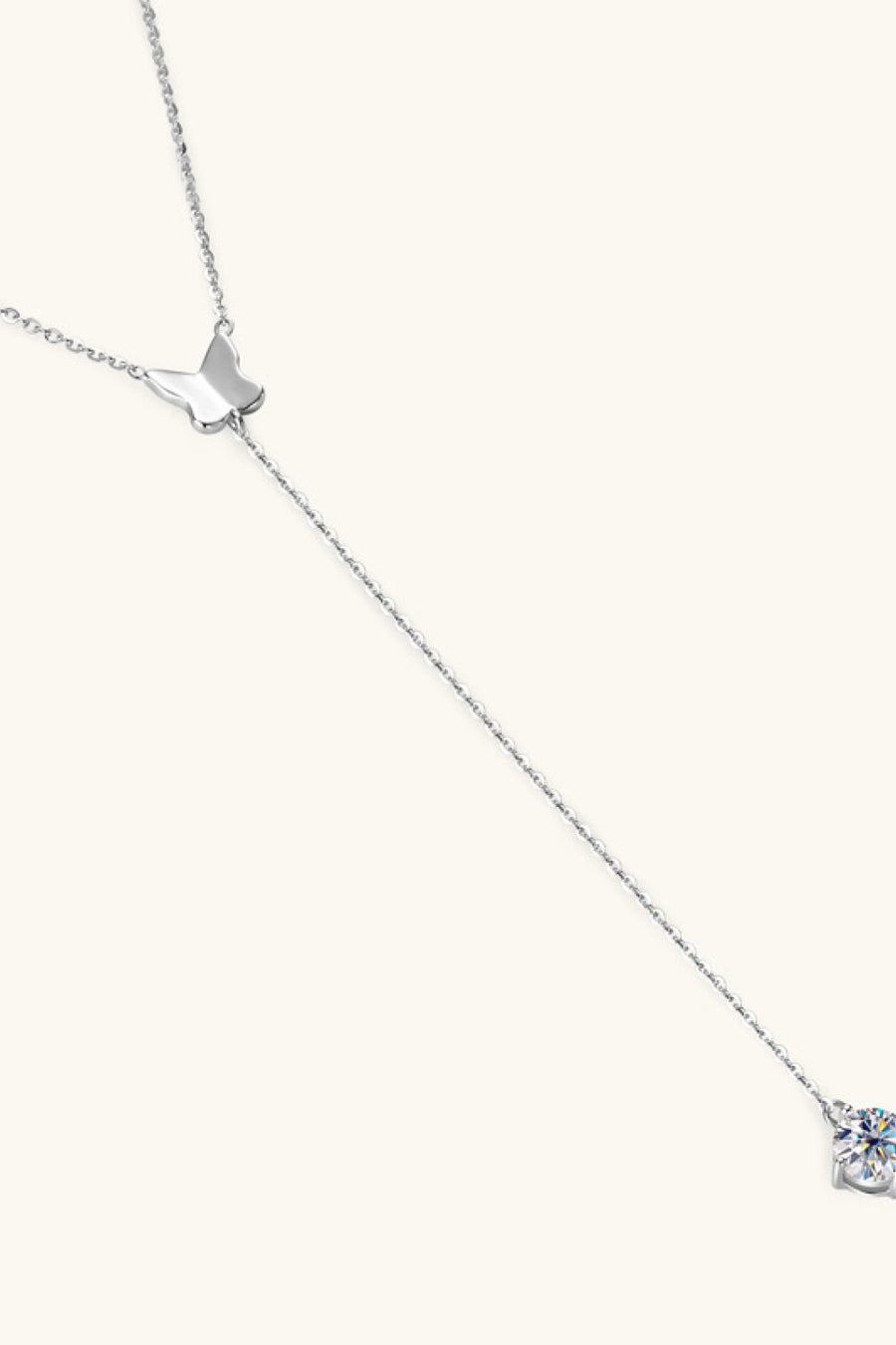 Silver lariat necklace with butterfly charm and moissanite pendant.