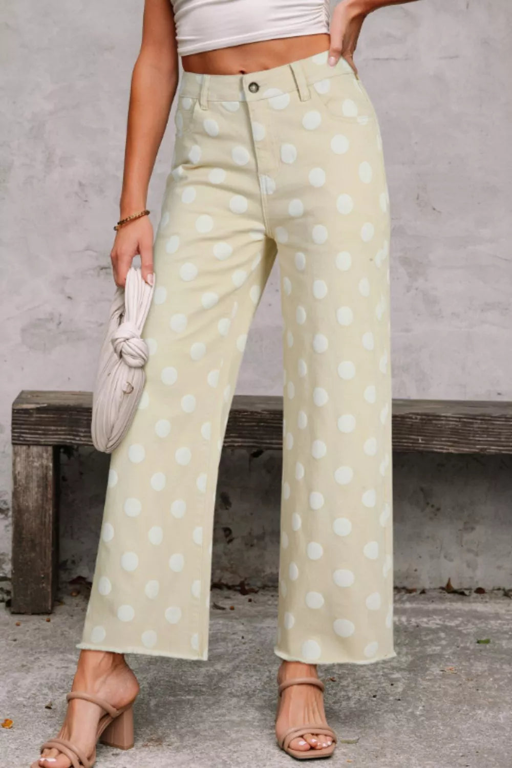 Polka dot high-waisted wide-leg jeans in light yellow denim with raw hem.