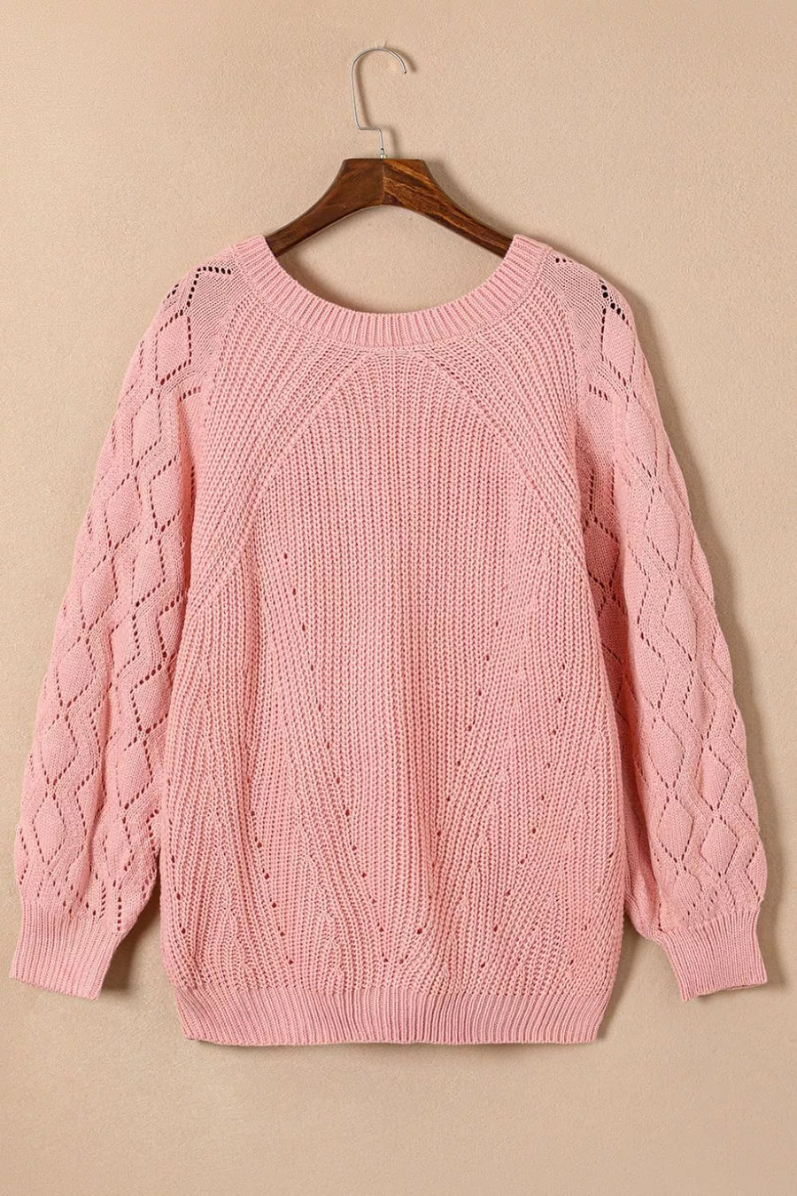 Dusty pink hollow-out knit sweater with puffy sleeves and diamond pattern detail.