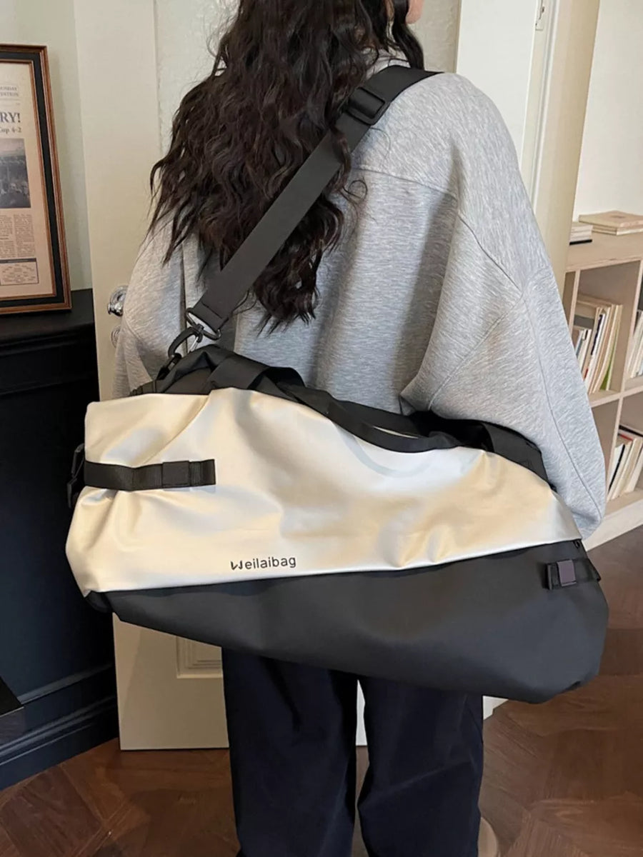 Oxford cloth travel bag in black and silver with adjustable strap and side buckles.