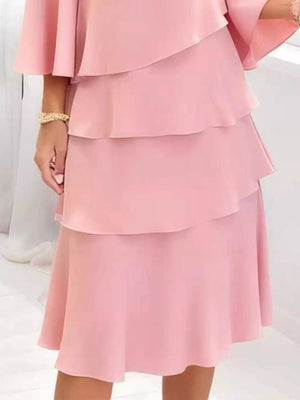 Elegant blush pink tiered dress with 3/4 sleeves and ruffled layers.