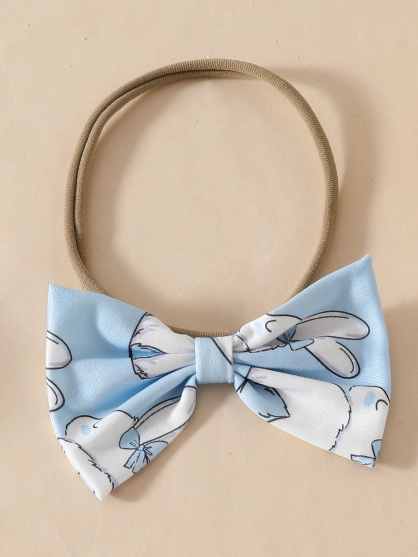 Sky blue baby headband with a bunny print bow and elastic band.