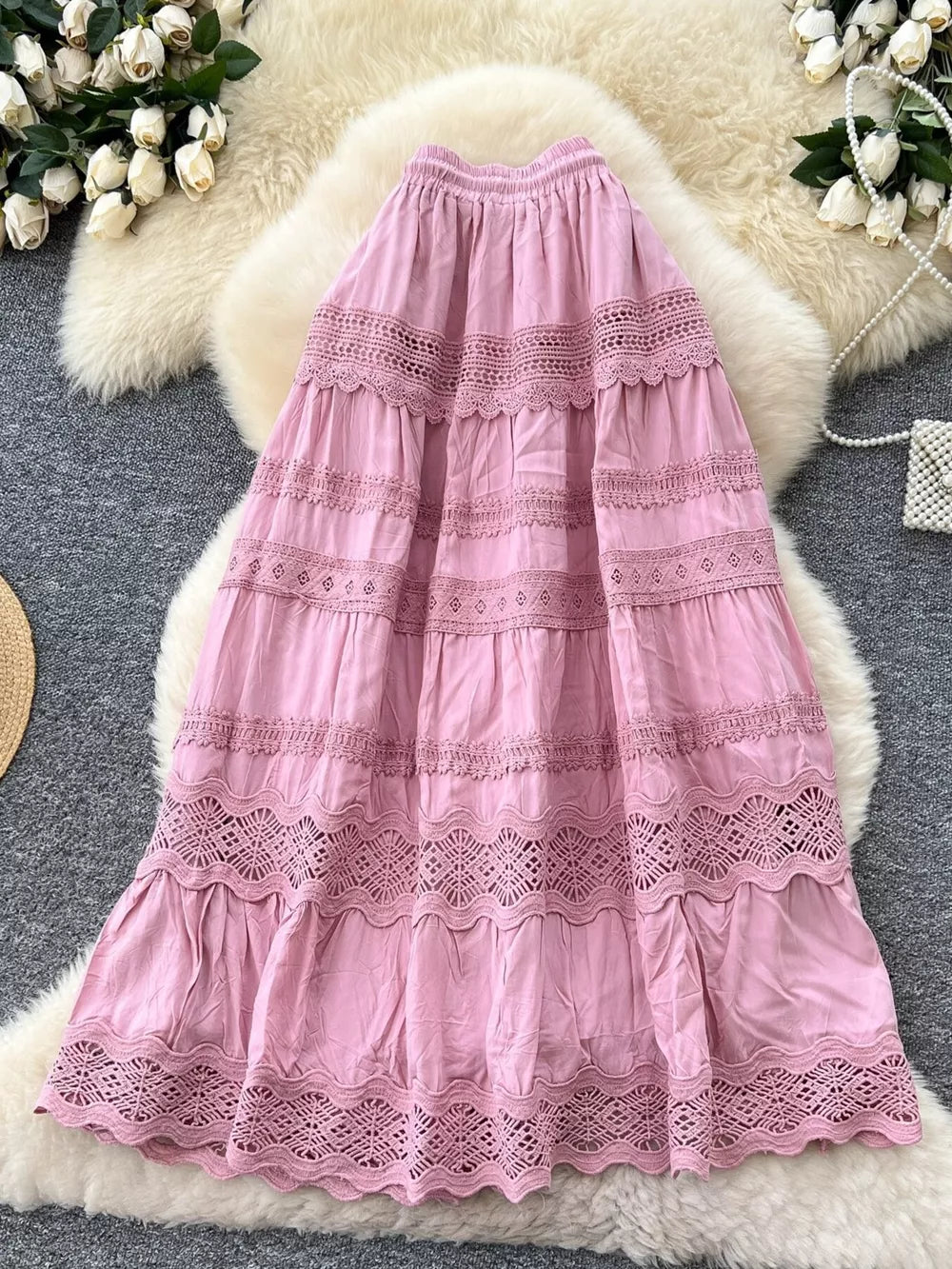 Pink tiered maxi skirt with lace trim and drawstring waist.