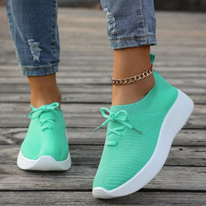 Light green breathable lace-up sneakers with white mid sole and white laces.