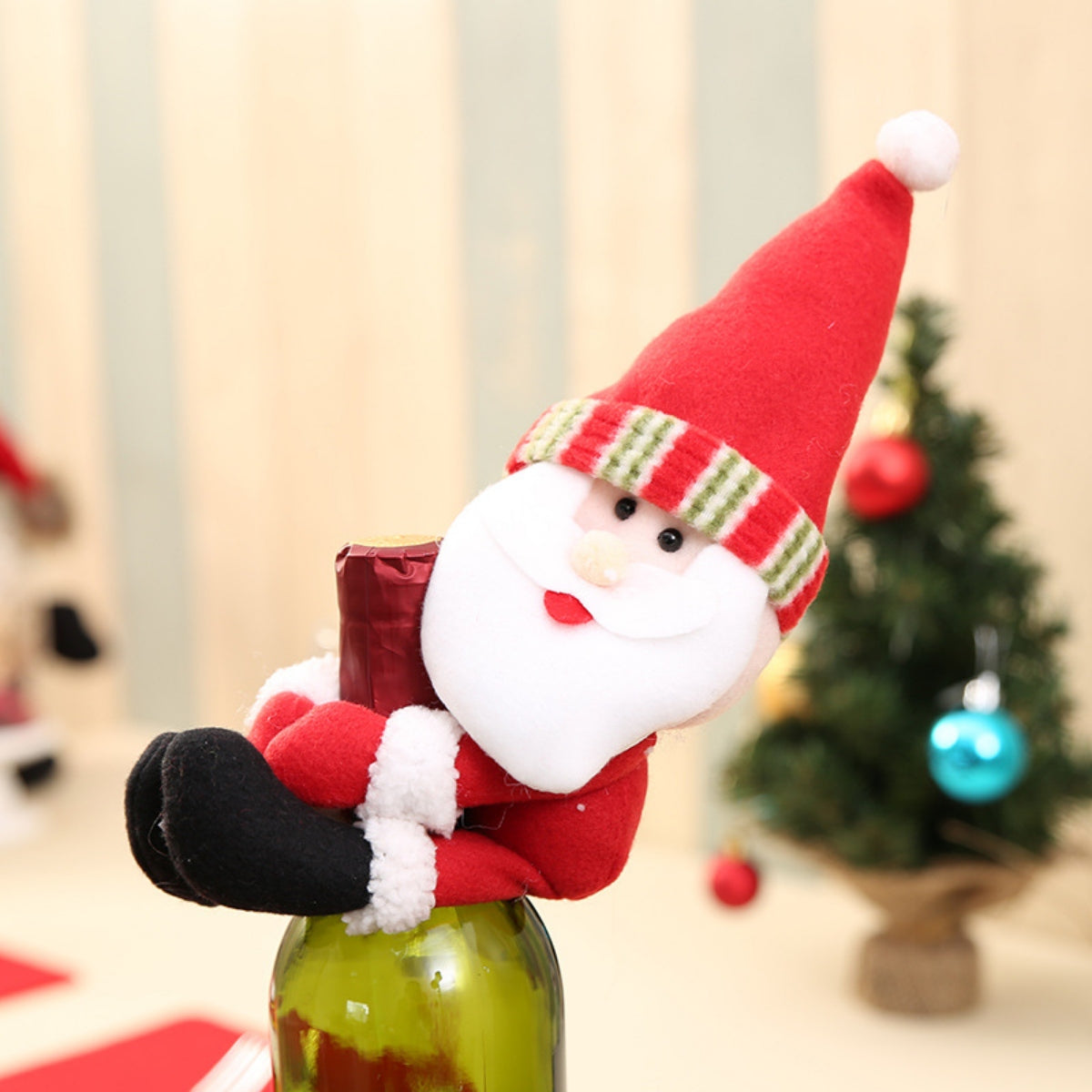 Santa Claus bottle topper with red hat and striped band, on a green bottle.