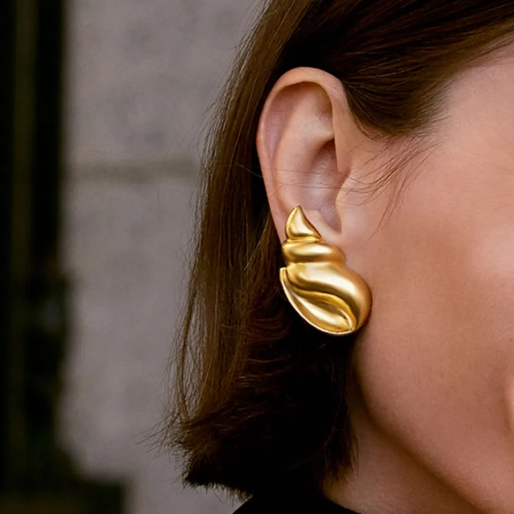 Sculptural seashell drop earrings in gold with a textured finish.