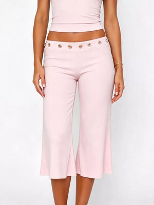 Pink maternity capri pants with flared hem and button detail at the waist.