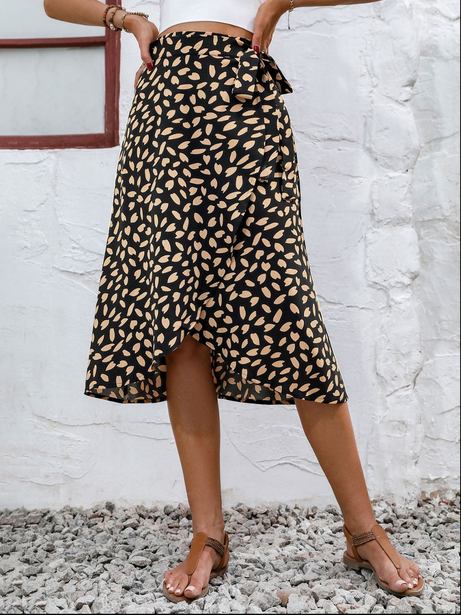 Black asymmetric wrap skirt with abstract print and tie waist