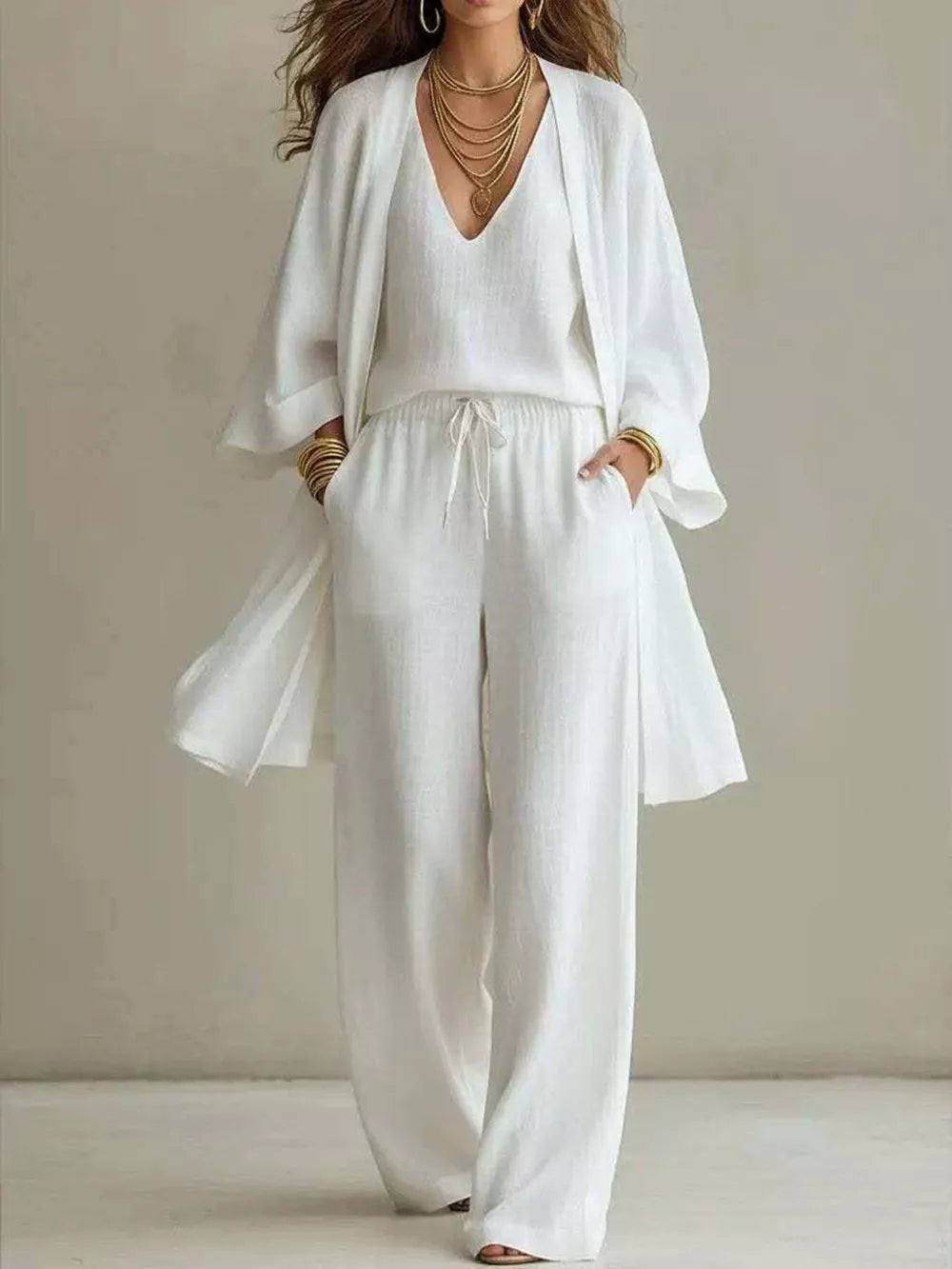 White linen wide leg pants with drawstring waist, V-neck tank top, and open front duster cardigan.