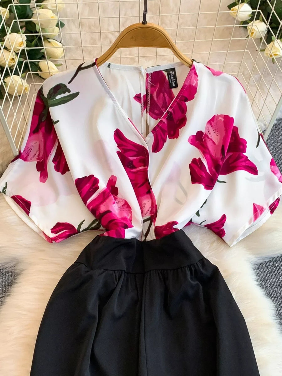 White abstract floral print wide-leg romper with black bottoms and pockets.