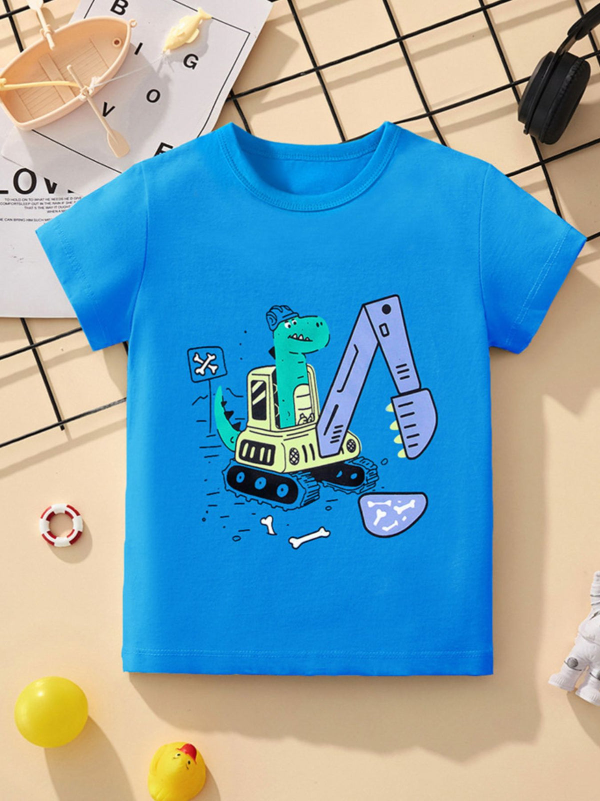 Blue toddler t-shirt with a green dinosaur driving a yellow and purple excavator graphic.