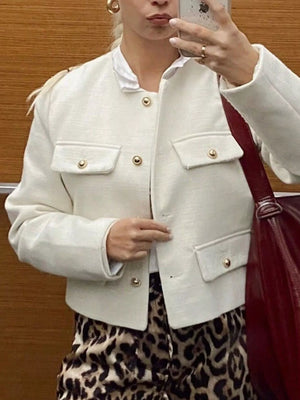White cropped tweed jacket with gold buttons and four front pockets.