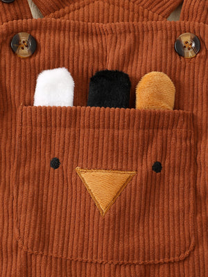 Brown corduroy overalls with bear face applique and plush ears peeking from pocket.