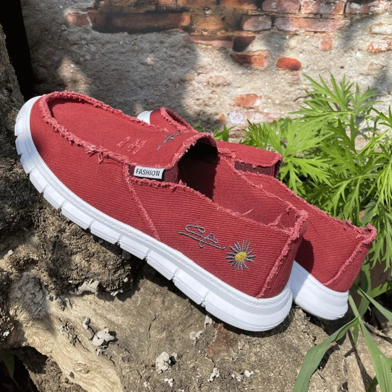 Deep Red canvas slip-on flats with raw edges and embroidered daisy detail.