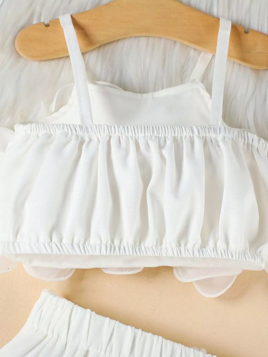 White baby cami with ruffled hem and matching ruffled shorts.