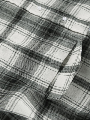 Button-up long sleeve cotton shirt in black and white plaid with a chest pocket.