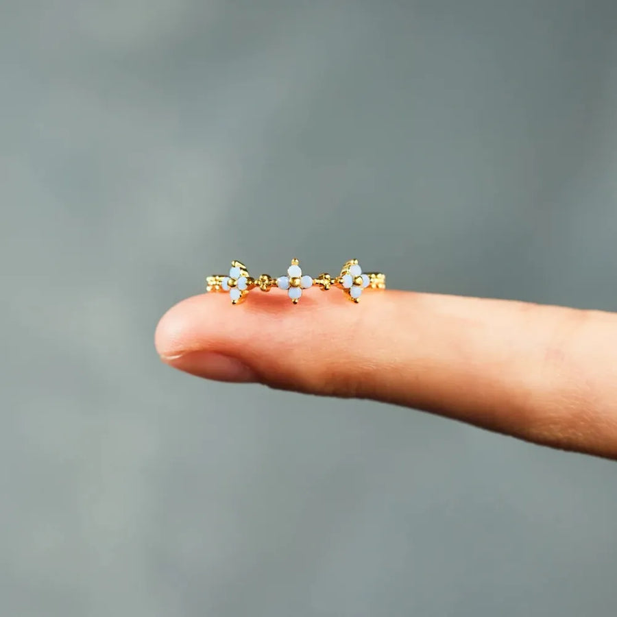 Gold band ring with celestial blossom details and small white stones