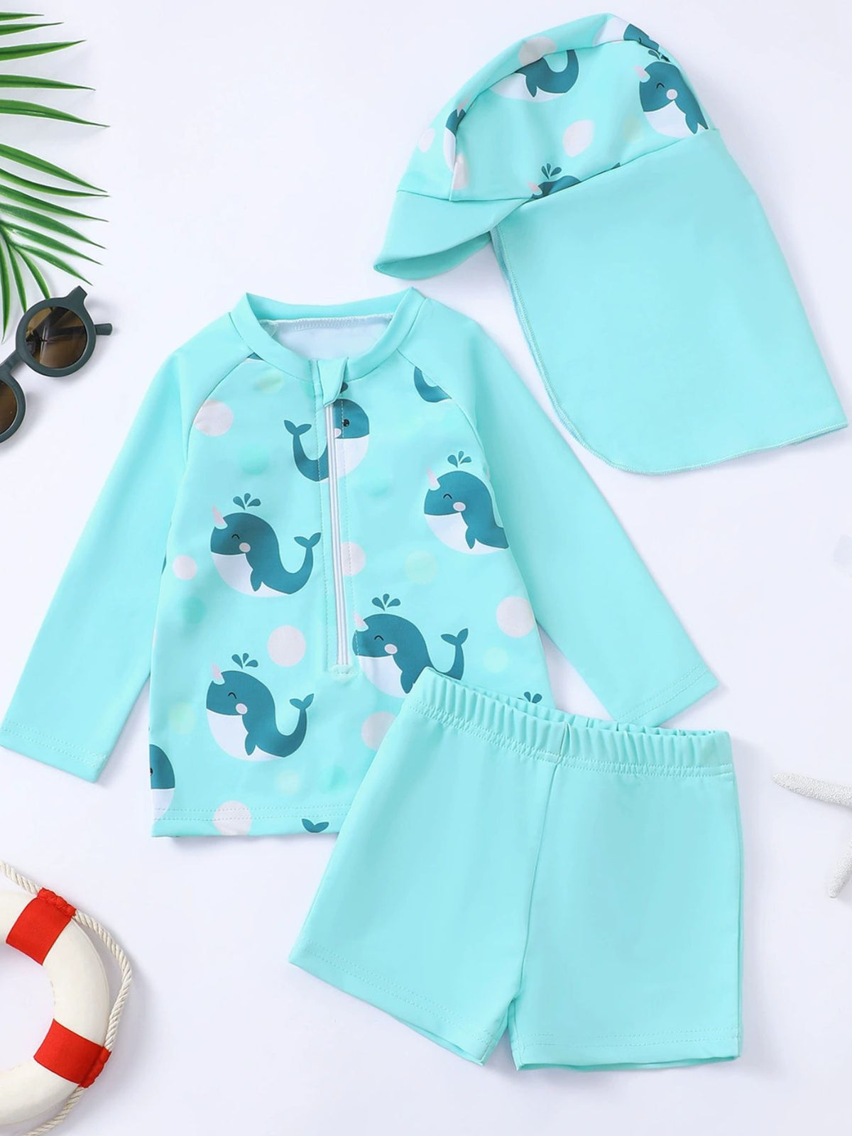 Children's turquoise whale print swimwear set with long sleeve rash guard, shorts, and sun hat.