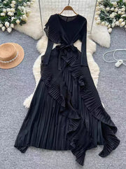 Black midi dress with ruffled asymmetrical pleated skirt and tie waist.