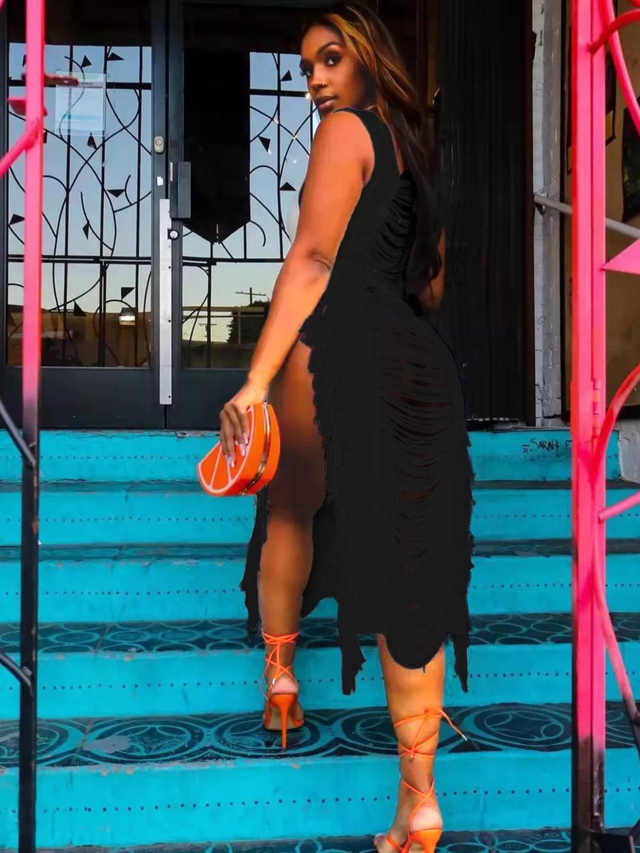 Black distressed fringe square neck midi dress with high slit, worn with orange lace-up heels.