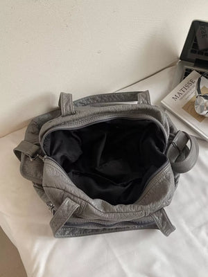 Gray faux leather tote bag with textured finish and black lining.