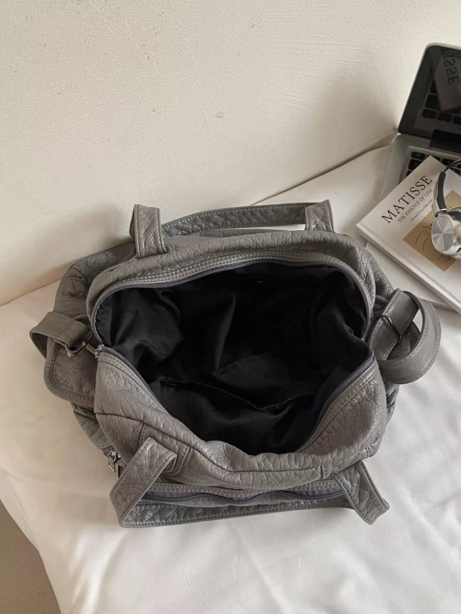 Gray faux leather tote bag with textured finish and black lining.