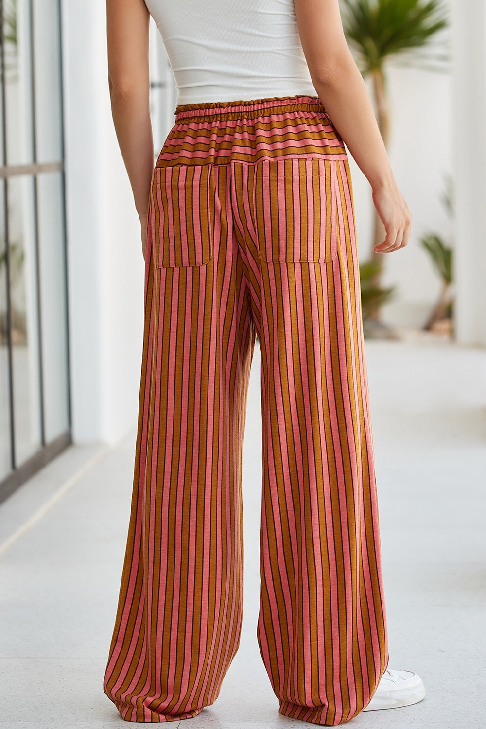 Wide leg drawstring pants in pink and brown vertical stripes with two back pockets.