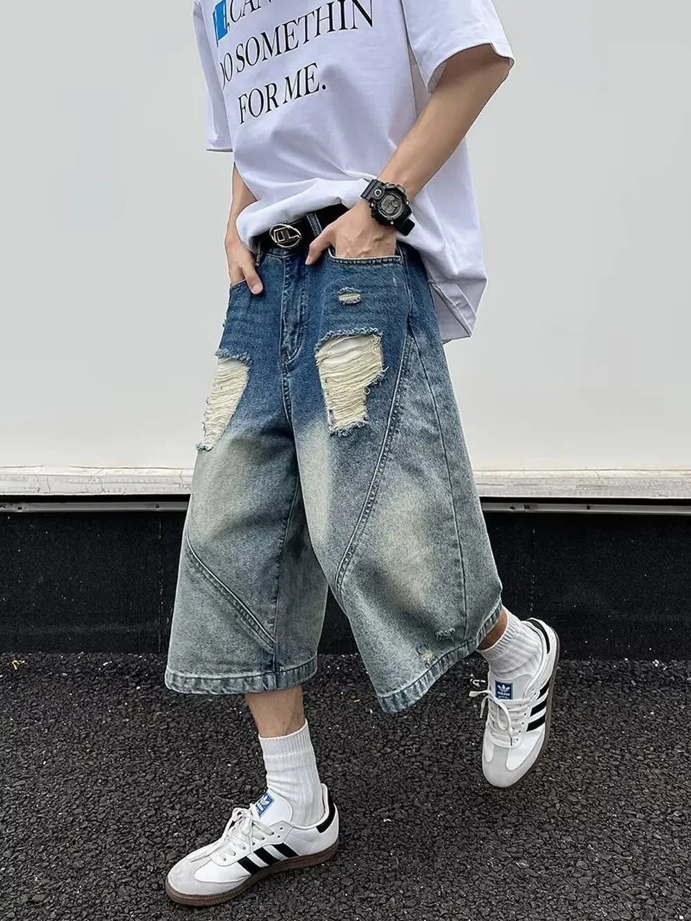 Men's distressed wide-leg denim shorts in light wash blue with ripped details.