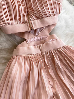 Pink pleated maxi dress with cutout detail and zipper closure.