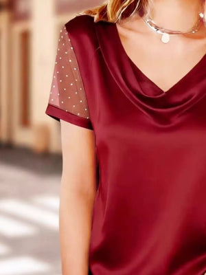 Burgundy satin cowl neck top with sheer polka dot sleeves.